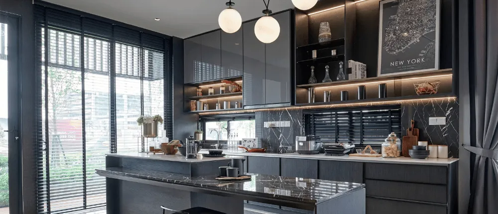 Cuisine moderne aux armoires noires et îlot de marbre